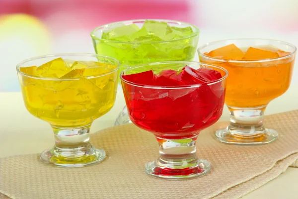 Tasty jelly cubes in bowls on table on light background — Stock Photo, Image