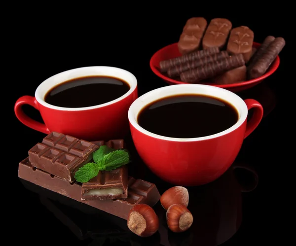 Red cups of strong coffee and chocolate bars isolated on black — Stock Photo, Image