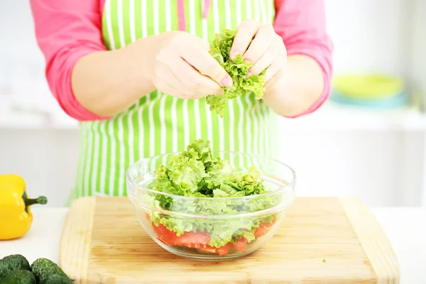 Gelukkig lachende vrouw in keuken bereiden plantaardige salade — Stockfoto