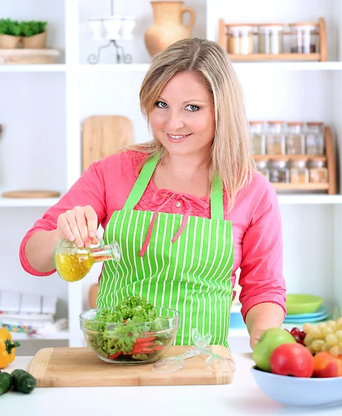 Mulher sorridente feliz na cozinha preparando salada vegetal — Fotografia de Stock