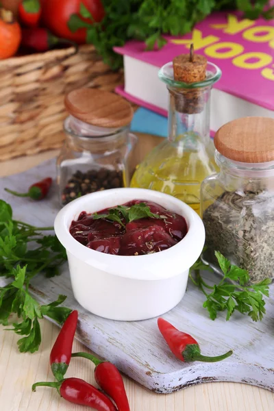 Foie cru dans un bol avec épices et condiments sur table en bois close-up — Photo