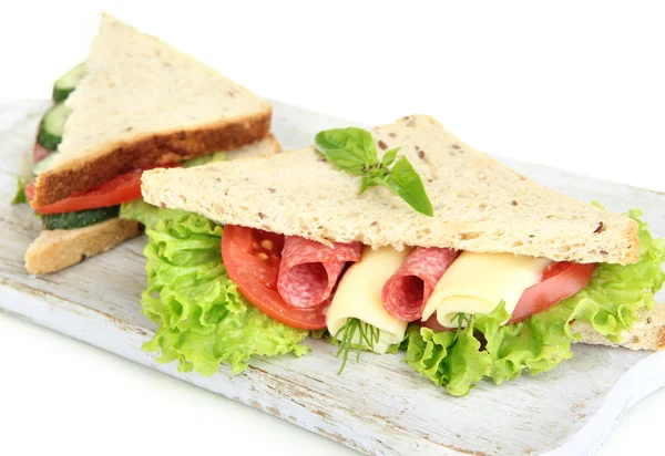 Tasty sandwiches with salami sausage and vegetables on cutting board, isolated on white — Stock Photo, Image