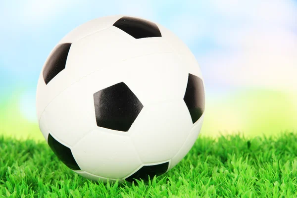 Soccer ball on green grass on bright background — Stock Photo, Image