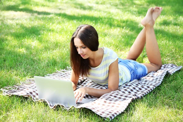 Beautiful young girl with laptop in park — Stock Photo, Image