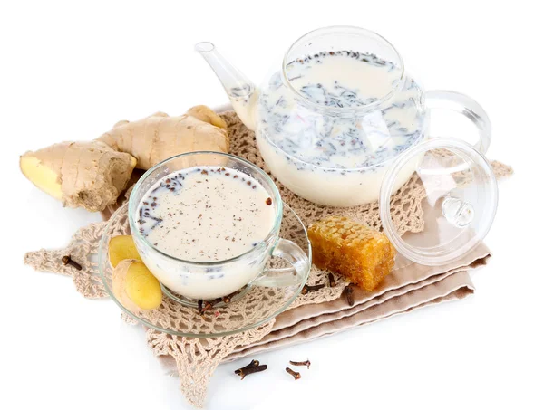 Teekanne und Tasse Tee mit Milch und Gewürzen auf Serviette isoliert auf weiß — Stockfoto