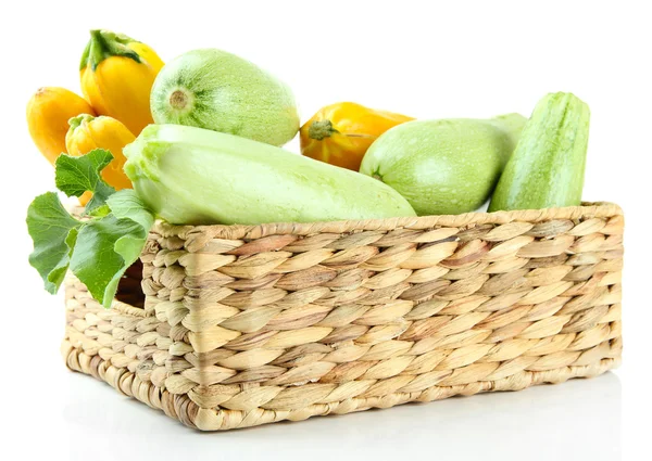 Courgettes jaunes et vertes crues dans une caisse en osier, isolées sur blanc — Photo