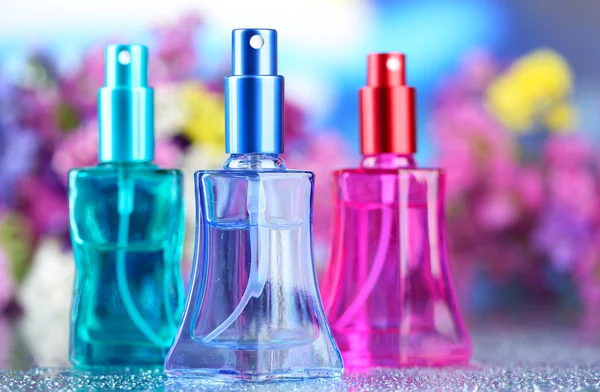 Perfumy kobiety w pięknych butelkach i kwiaty — Zdjęcie stockowe