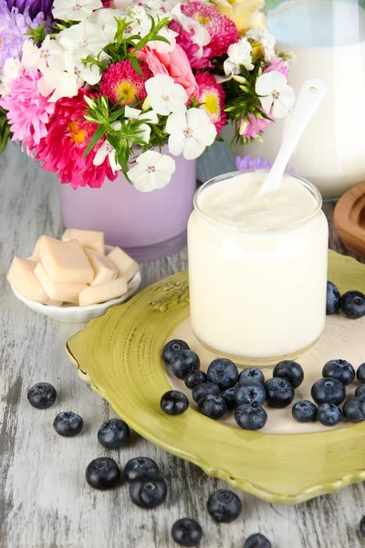 Verse zuivelproducten met bosbessen op houten tafel close-up — Stockfoto