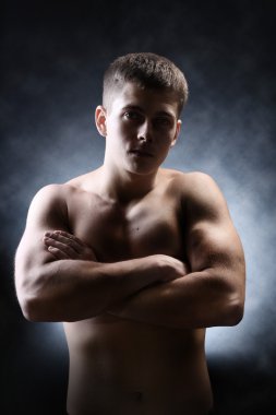 yakışıklı genç kaslı sporcu, koyu arka plan üzerinde