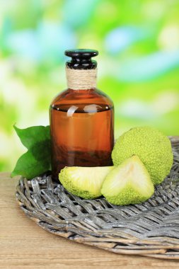 Osage turuncu meyveler (maclura pomifera) ve doğa zemin üzerine ahşap masa üstünde ilaç şişesi