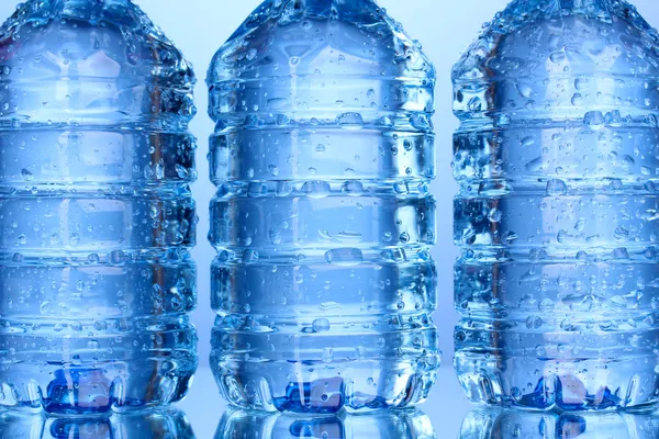 Plastic bottles of water close-up on blue background — Stock Photo, Image