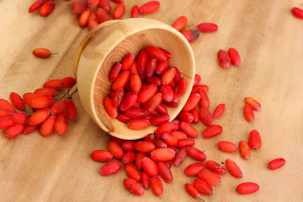 Ripe barberries in wooden bowl, on wooden background — Stock Photo, Image