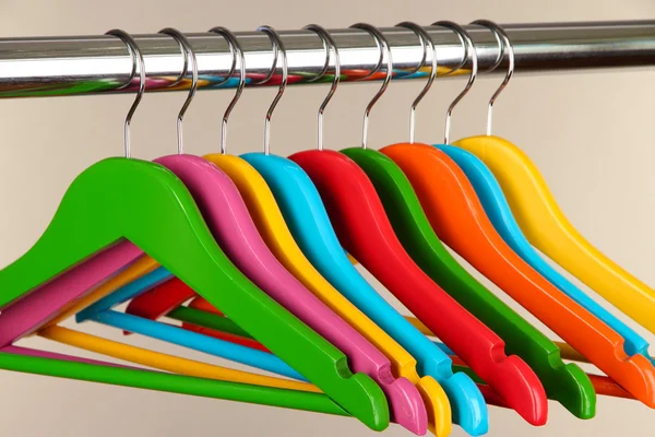 Kleurrijke kleerhangers op grijze achtergrond — Stockfoto