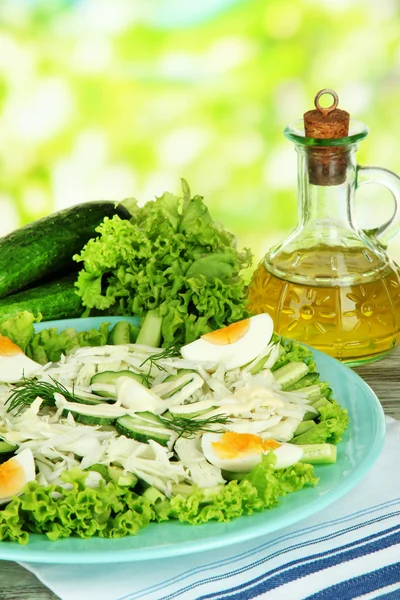 Delicious salad with eggs, cabbage and cucumbers on wooden table — Stock Photo, Image