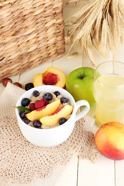 Harina de avena en taza con bayas en servilletas sobre mesa de madera — Foto de Stock