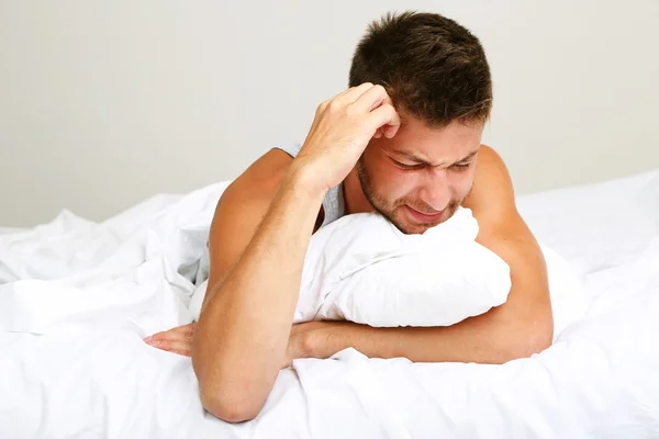 Schöner junger Mann im Bett — Stockfoto