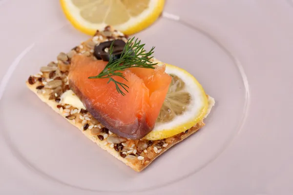 Zalm sandwich op plaat op houten tafel close-up — Stockfoto