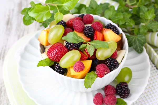 Salade de fruits dans un bol, sur fond de table en bois — Photo