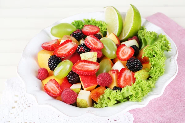 Salada de frutas em placa em guardanapo mesa de madeira — Fotografia de Stock