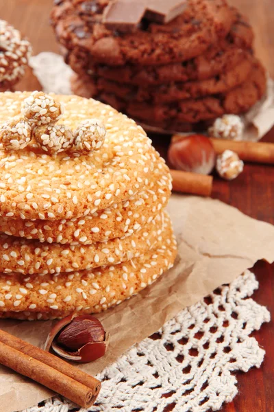 Biscotti fatti in casa con semi di sesamo, cioccolato, su tovagliolo, su sfondo di legno — Foto Stock