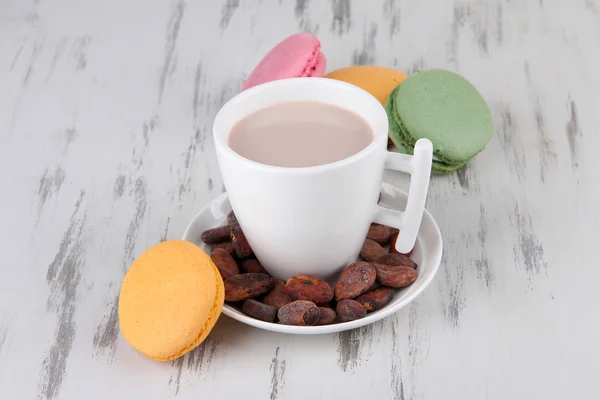 Cocoa drink, macaroni and cocoa beans on wooden background — Stock Photo, Image