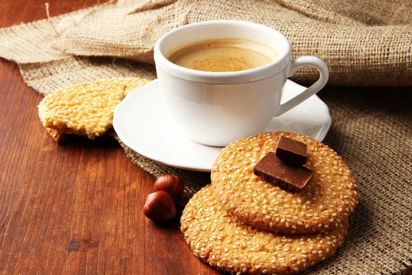 Cup of tasty coffee with tasty cookies, on wooden background — Stock Photo, Image