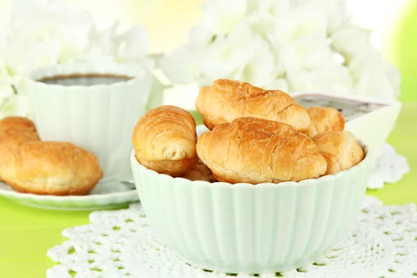 Croissants saborosos e xícara de café na mesa close-up — Fotografia de Stock