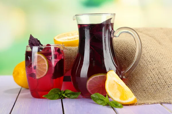 Röd basilika saft i kannan och glas, på träbord, på ljus bakgrund — Stockfoto