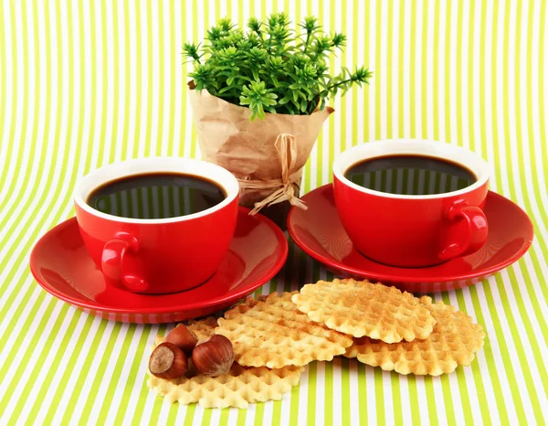 Красные чашки крепкого кофе вафли на полосатом фоне — стоковое фото
