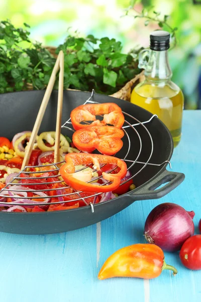 Vegetables in wok on wooden table on natural background — Stock Photo, Image