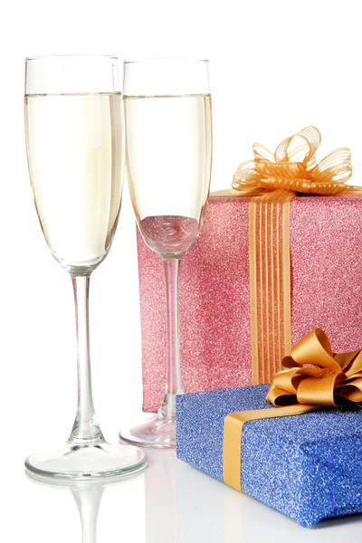 Glasses of champagne with gift boxes isolated on white — Stock Photo, Image