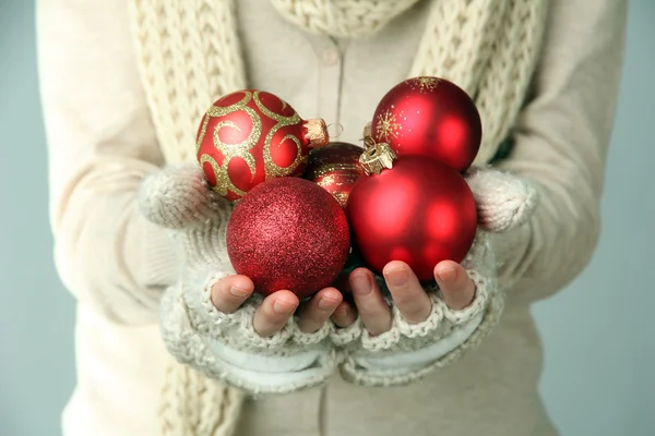 女性の色の背景上のクリスマス ツリーのボール ミトンの手します。 — ストック写真