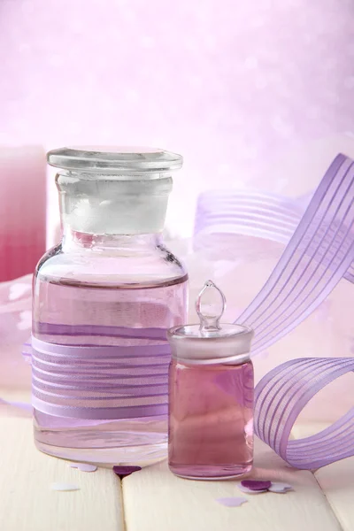 Glasflaskor med färg väsen, på ljus bakgrund — Stockfoto