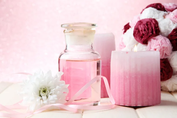 Botella de vidrio con esencia de color, sobre fondo rosa —  Fotos de Stock