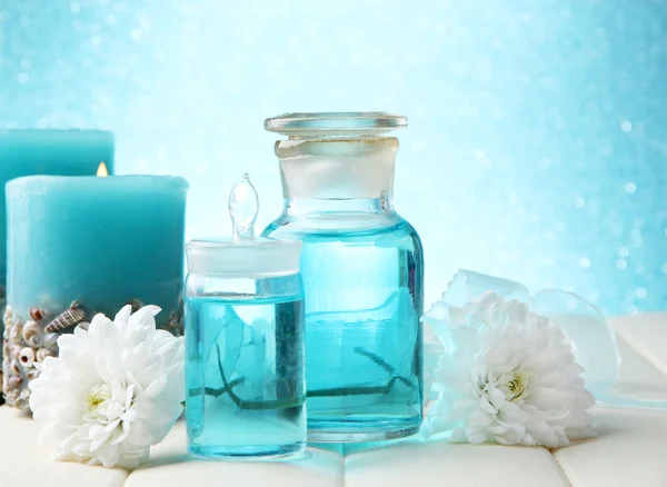 Glass bottles with color essence, on wooden table, on blue background — Stock Photo, Image