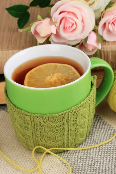 Csésze tea kötött dolog rajta közelről — Stock Fotó