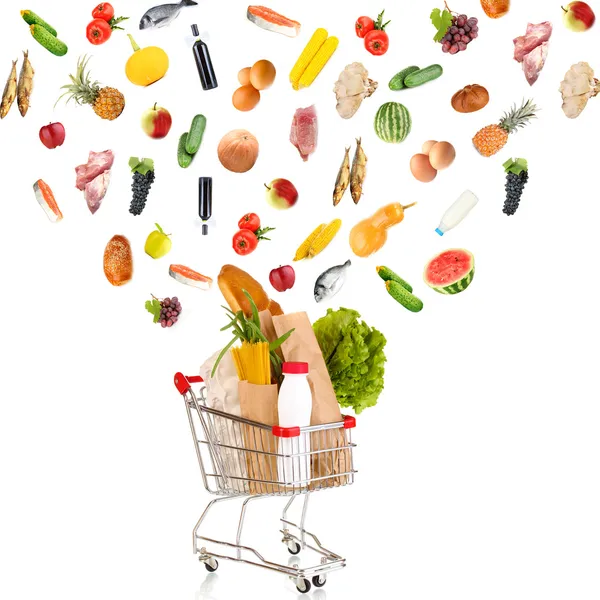 Produtos alimentares voando para fora do carrinho de compras isolado em branco — Fotografia de Stock