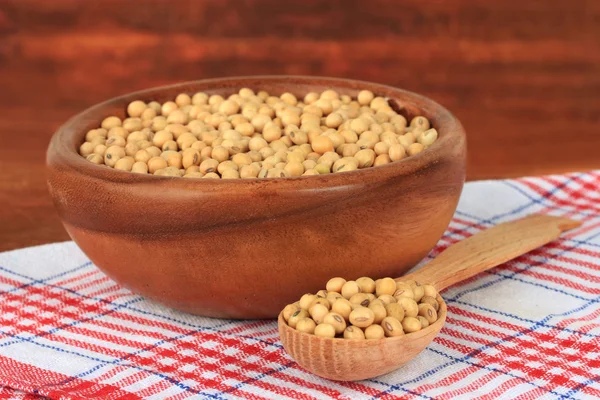 Sojabonen op tafel op houten achtergrond — Stockfoto