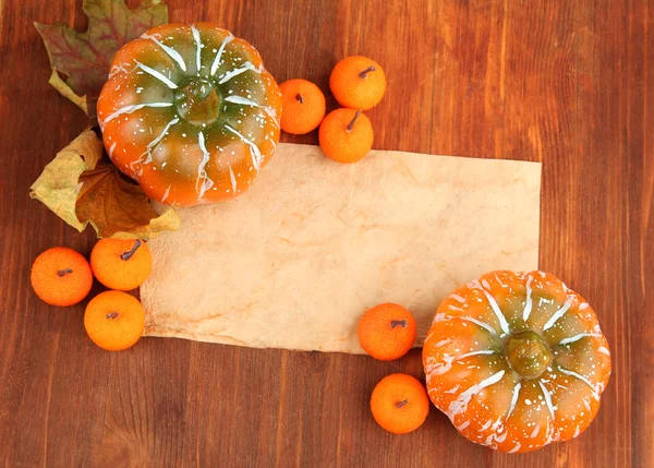 Old paper, small tangerines and pumpkins on wooden background — Stock Photo, Image