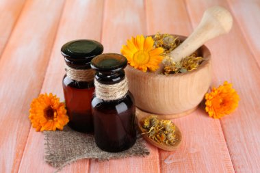 ilaç şişeleri ve ahşap zemin üzerine calendula çiçekler
