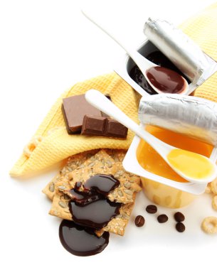 Açık plastik bardak ve bal tarak, meyve ve Çökeltmeler beyaz izole peçete üzerinde lezzetli tatlılar