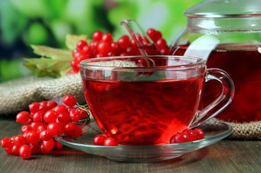 Bodegón con té de viburnum en servilleta de tela de saco, sobre fondo de madera