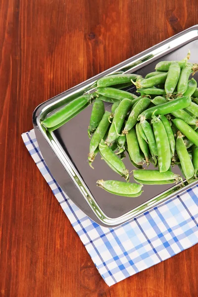 Gröna ärtor på servett på bordet — Stockfoto