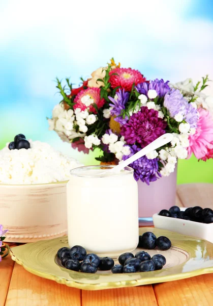 Frische Milchprodukte mit Blaubeeren auf Holztisch in Großaufnahme — Stockfoto