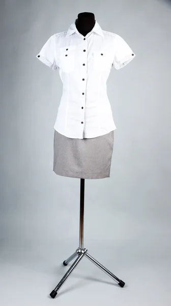 Bonita blusa y falda gris en maniquí, sobre fondo gris —  Fotos de Stock