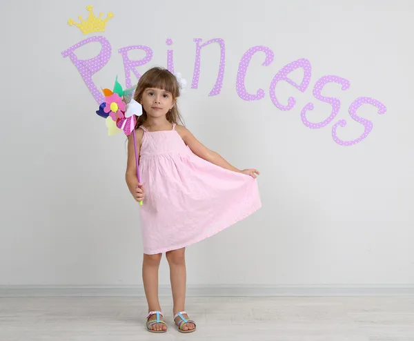 Little girl posing on grey wall background — Stock Photo, Image