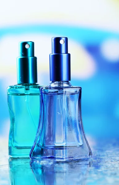 Perfume de las mujeres en hermosas botellas sobre fondo brillante — Foto de Stock