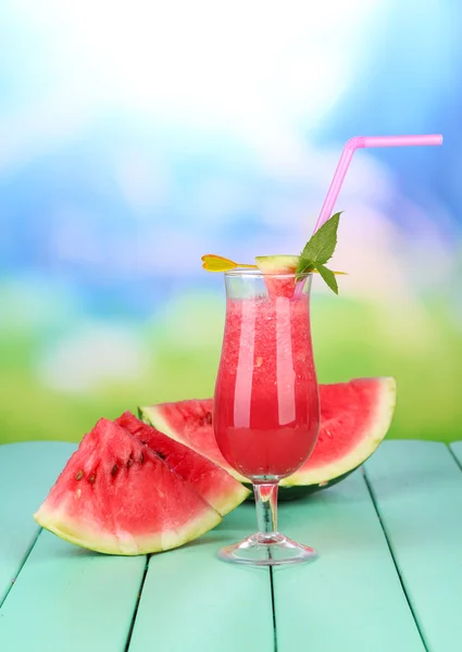 Copo de suco de melancia fresca, em mesa de madeira, sobre fundo brilhante — Fotografia de Stock