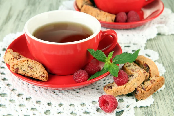 Cups of tea with cookies and raspberries on table close-up — Stock Photo, Image