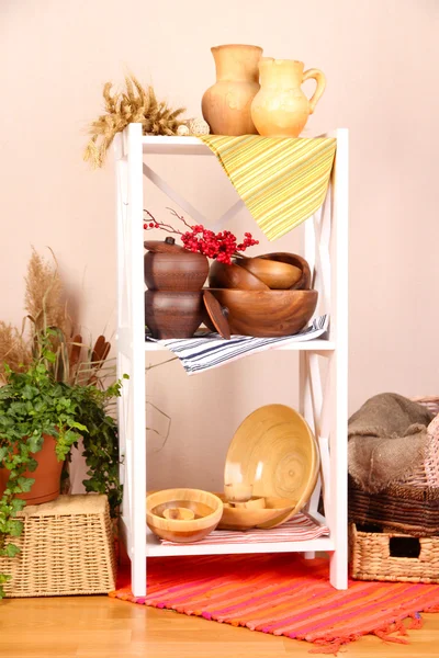 Hermosos estantes blancos con vajilla y decoración, sobre fondo de pared de color — Foto de Stock